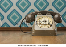 stock-photo-vintage-gray-telephone-on-hardwood-floor-diamond-light-blue-retro-wallpaper-on-background-212598148